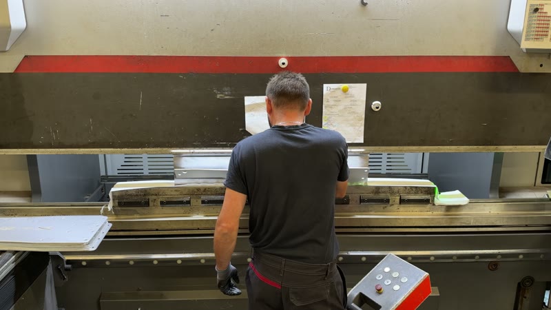 L’opérateur devant la presse de pliage
