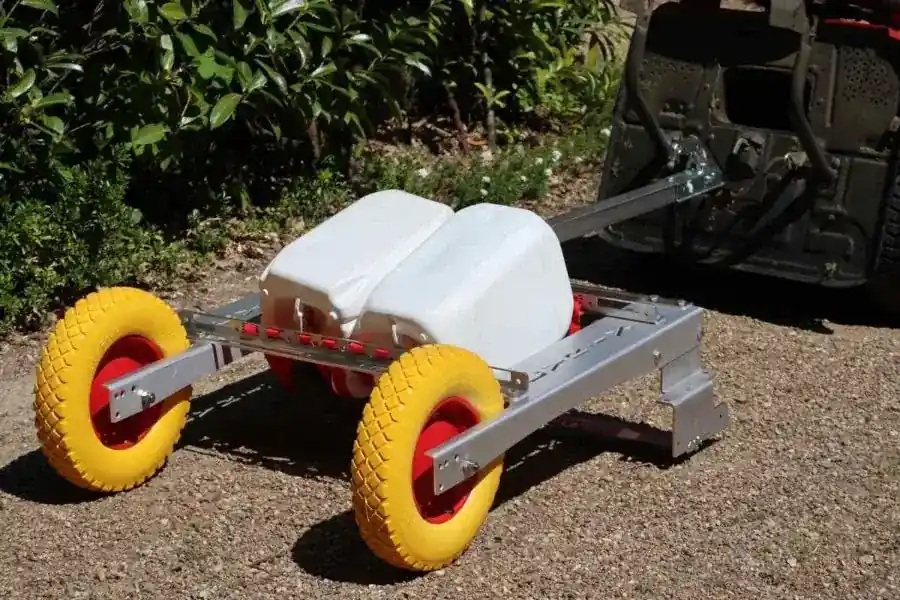 Le RBVx100 attelé derrière un quad sur une allée en gravier
